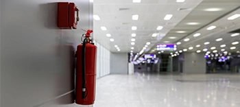 two fire extinguishers in industrial hallway